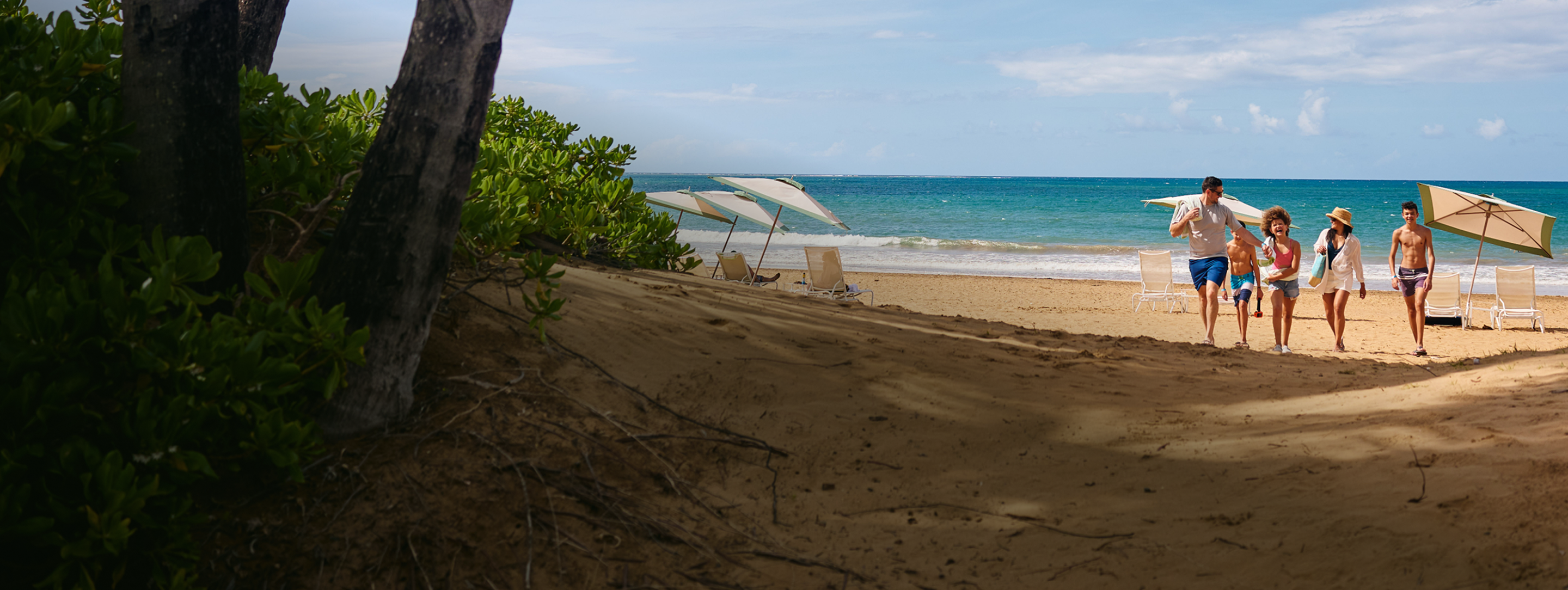 Family walking on the beach at a Margaritaville Vacation Club resort